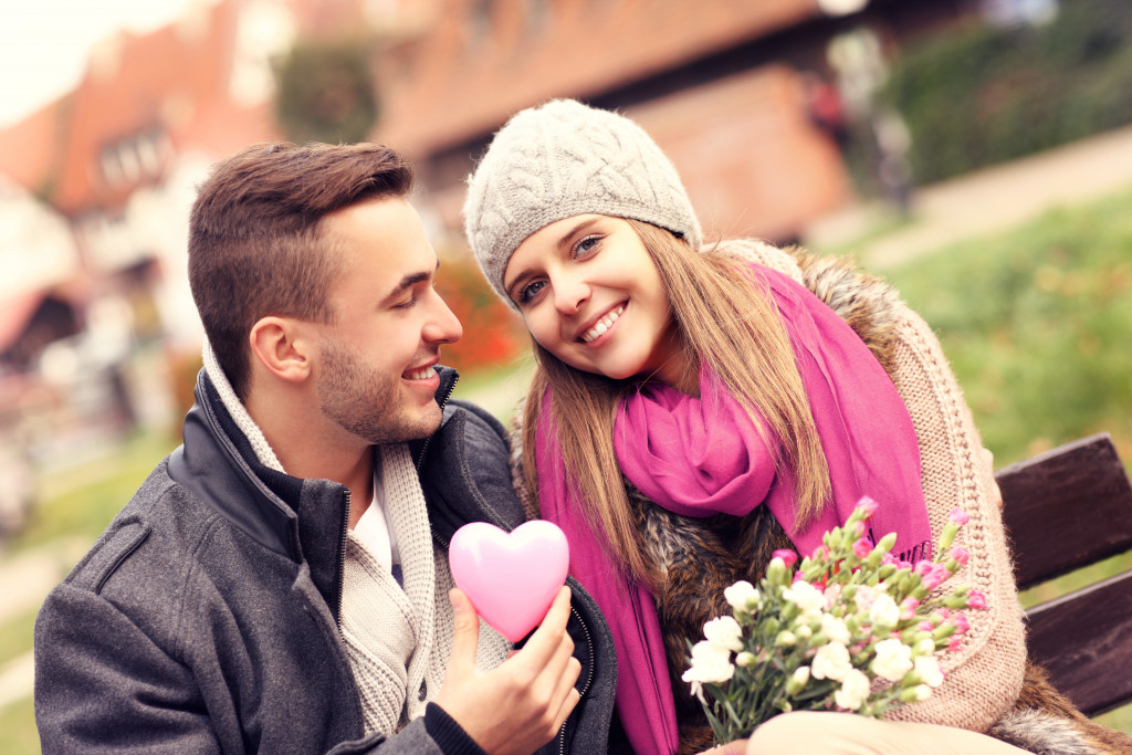A picture of a couple on Valentine's Day in the park with flowers and heart