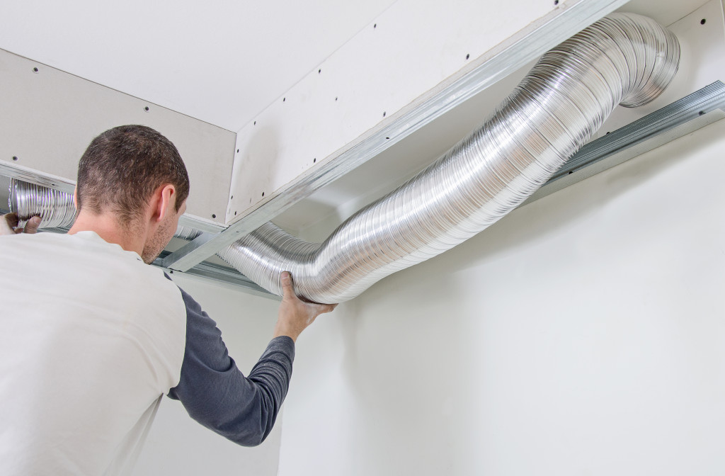 an HVAC technician on a ventilation system